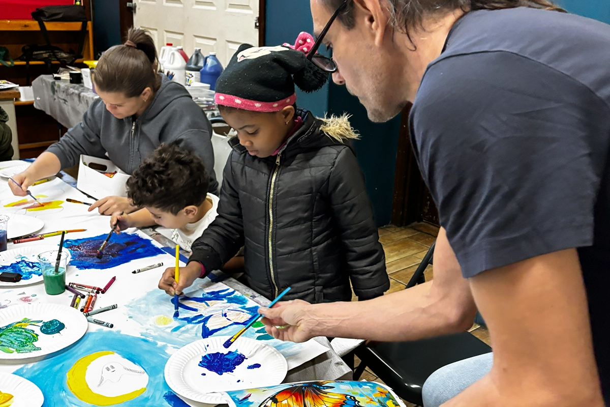 Art teacher guiding students during a children's art class at The Belfry Centre in Brooklyn.